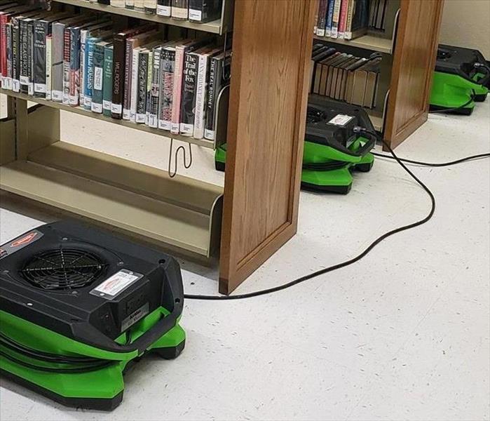 SERVPRO fans set between the aisles of books in the library.